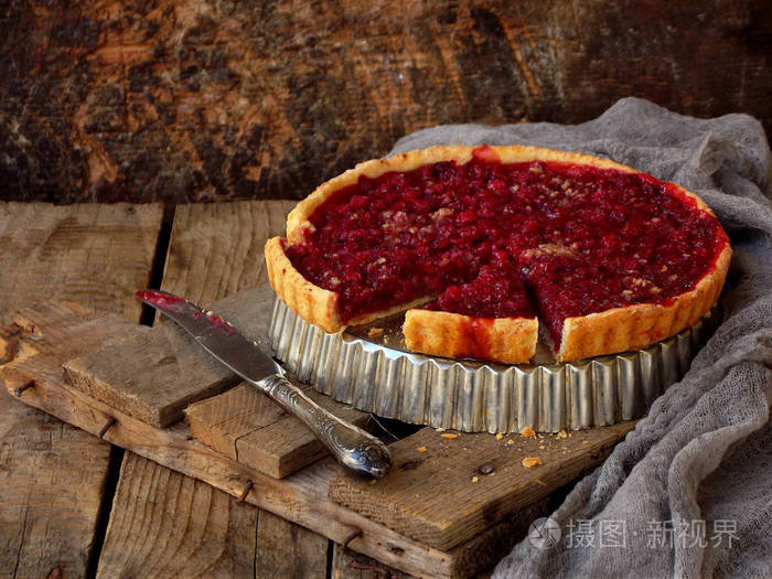 蛋挞 蛋糕与红色小红莓和核桃木的背景上。莓果馅饼。文本的空间