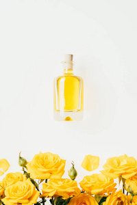 白色的香水瓶和黄色玫瑰的顶端视图