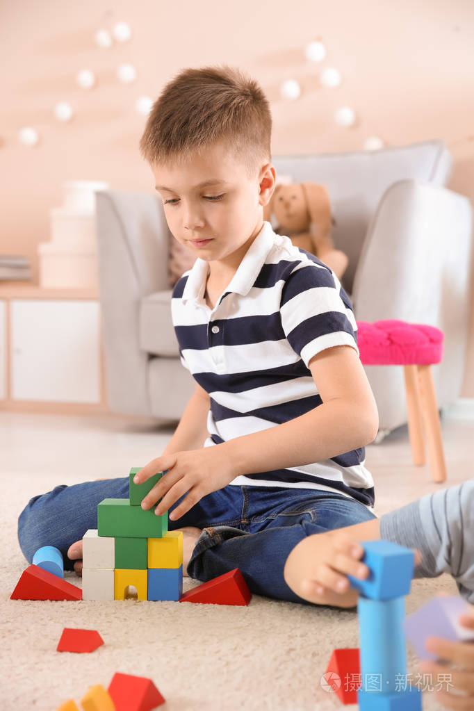 可爱的小孩子玩积木在地板上 室内