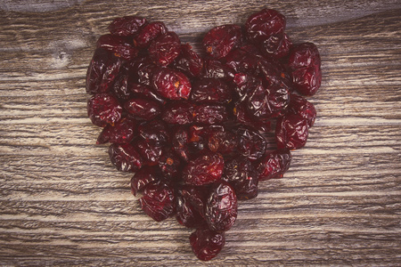 老式的照片，木制的桌子上的红色小红莓的心