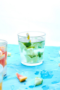 健康排毒柑橘水或柠檬汁在浅蓝色背景。清新夏日自制鸡尾酒配柠檬石灰橙和葡萄柚