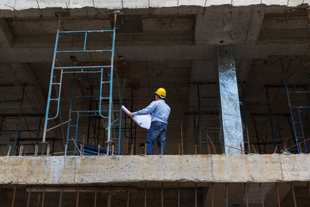 建设概念，工程师和建筑师在建筑地盘工作与蓝图