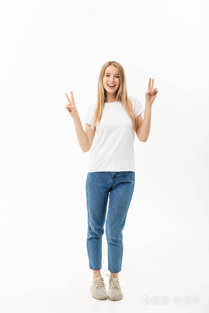 个快乐的年轻女子的全长肖像站立和显示和平手势与两只手隔绝白色背景