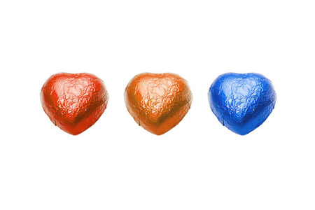 三彩色巧克力心糖果白色背景图片