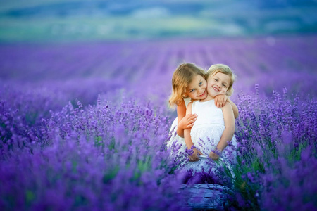 两个可爱的小女孩摆在薰衣草领域