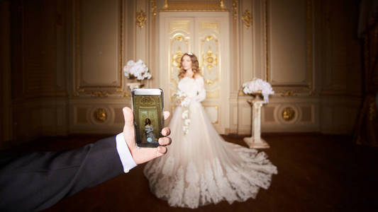 在豪华内饰的巴洛克风格的智能手机拍摄新娘