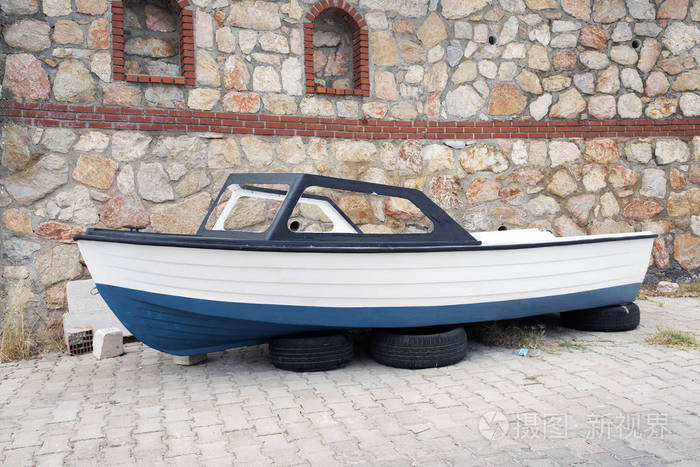在土耳其的博德鲁姆大街上, 一艘渔船在汽车车轮上。