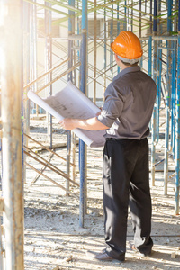 建设概念，工程师和建筑师在建筑地盘工作与蓝图