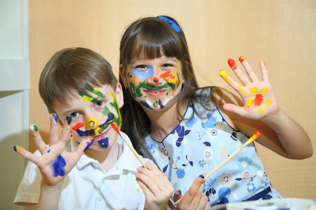 用颜料在他们脸上的快乐儿童。创造力和教育理念。儿童画的脸上颜色