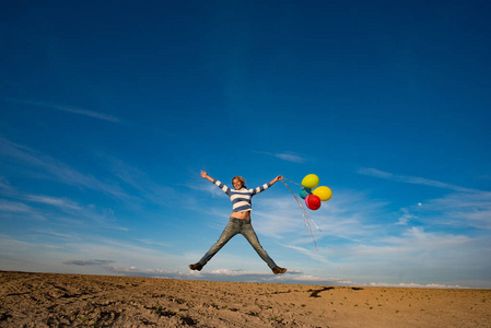 无忧无虑的女孩,与五颜六色的气球跳照片