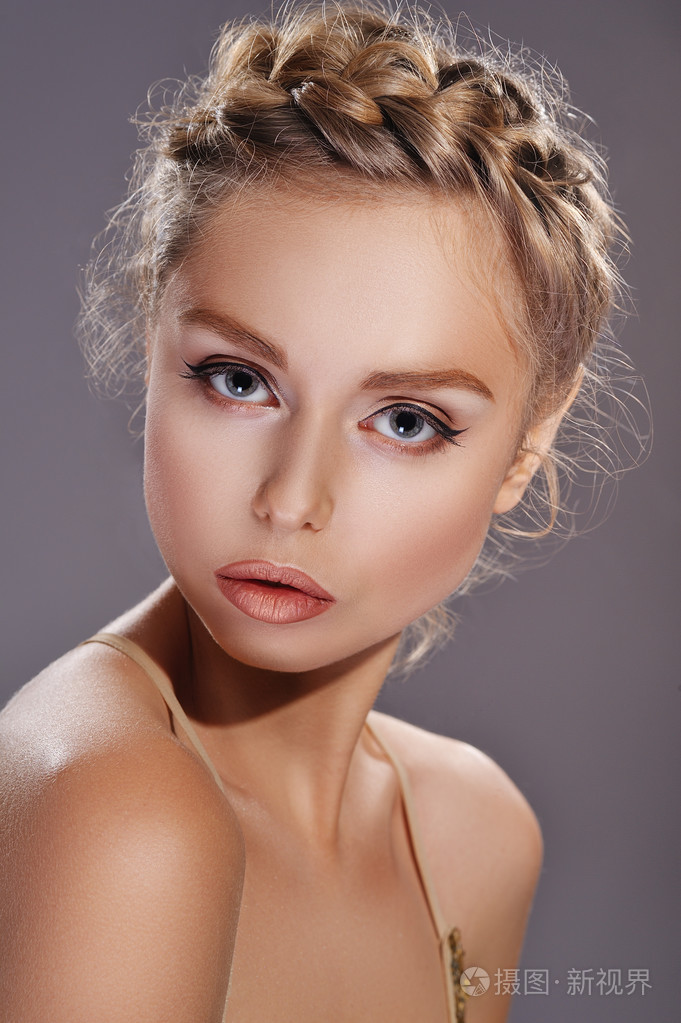 金色的化妆和时髦的希腊辫子的女人