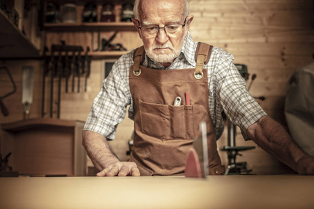 资深木匠在工作与 tablesaw 在他的车间