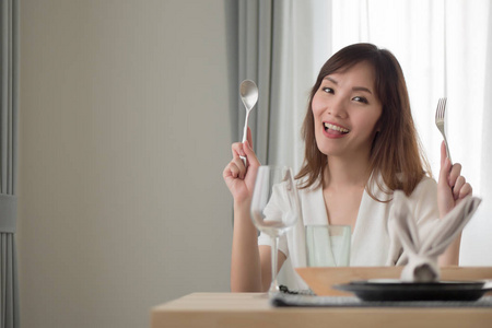 妇女在适当的餐桌上用餐手持勺子和叉子的亚洲妇女肖像餐饮亚洲风味餐具女性食品饮品餐饮理念亚洲30s 成年女性模特