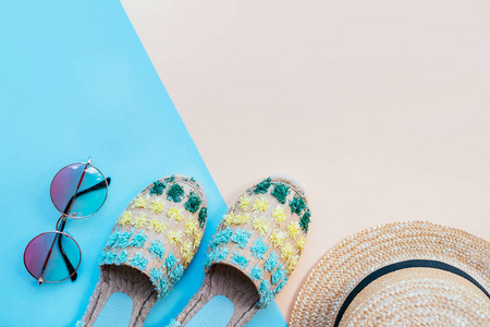 夏季时尚 flatlay 与渐变圆形太阳镜, 草帽和 espadrille 凉鞋两色调的蓝色和米色背景。完美的海滩设置在海上度假