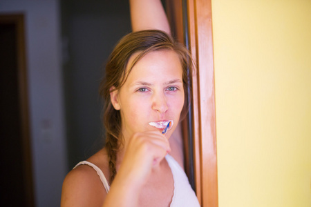 形象的漂亮女性，站在镜子前她刷牙