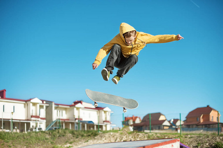 一个少年滑板并在郊区的城市滑板翻转技巧