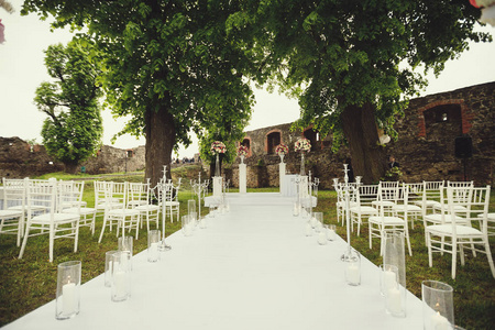 公园里绿草上的婚礼拱门和椅子。婚礼庆典装饰品