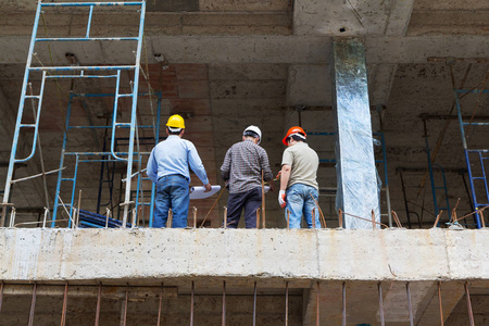 建设概念，工程师和建筑师在建筑地盘工作与蓝图