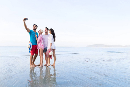 年轻人们组自拍照合影在单元格上的海滩上智能手机的暑假，快乐微笑朋友海假日