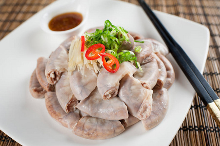 对亚洲的白盘子里煮的猪大肠照片