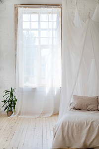 卧室里的软光色调与木地板。大舒适的四海报双人床在典雅的经典卧室。天然白色与木室内设计
