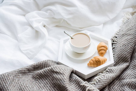 在床上的舒适早餐, 杯咖啡和牛角面包白色和