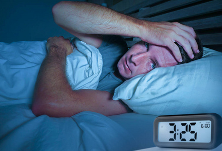 忧虑哀伤的年轻有吸引力的人醒着躺在床上, 睁大眼睛失眠睡眠障碍抑郁