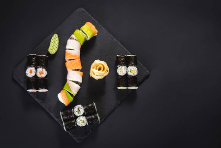 一套不同的寿司卷与鱼子酱黑色背景