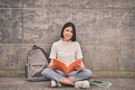 教育理念。亚洲妇女在大学里看书。美丽的女人在大学里放松。美丽的女人很高兴阅读。亚洲女孩喜欢学习。亚洲妇女教育