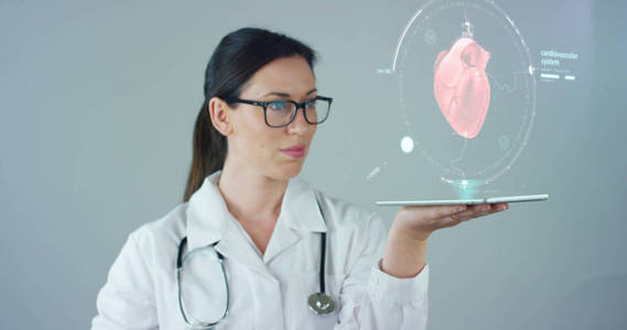 女医生白大衣与听诊器，全息片代表病人的身体 心肺 肌肉 骨头。概念 未来医学 世界援助和未来