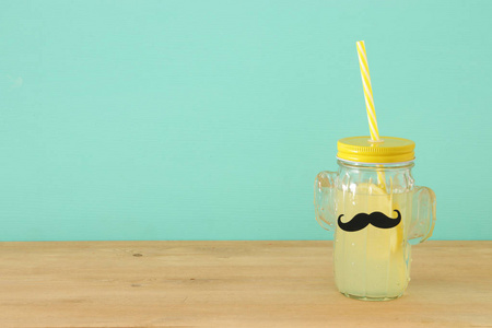 新鲜柠檬水饮料的形象在可爱的仙人掌形状的眼镜戴胡子, 在木桌上。父亲节概念
