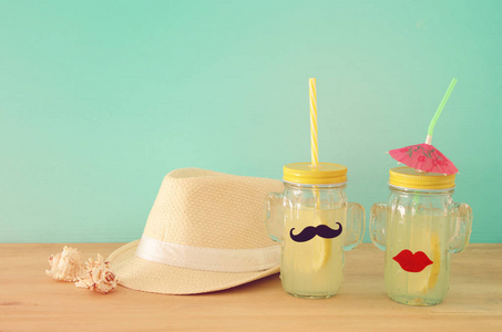 新鲜柠檬水饮料的形象在可爱的仙人掌形状的眼镜戴着胡子和嘴唇, 在木桌上。热带夏日浪漫假期概念