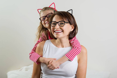 女儿亲切地拥抱她的母亲.眼镜的父母和孩子照片