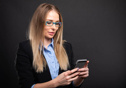 戴蓝色眼镜的商务女士在 smartphon 发短信