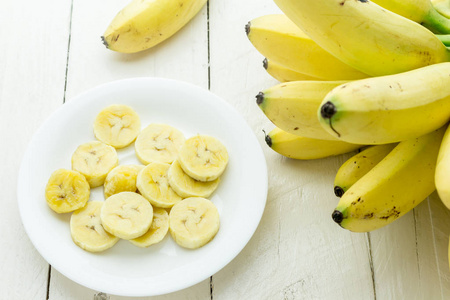 香蕉和一块切碎的香蕉在木桌上