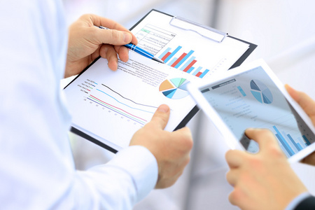 业务的同事工作和分析财务数据在平板电脑上数字照片