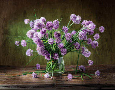 木制的桌子上的花瓶中的洋葱 韭菜 花束照片