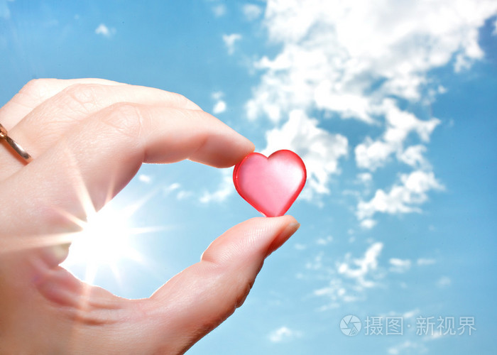 手捧小半透明的心在天空中