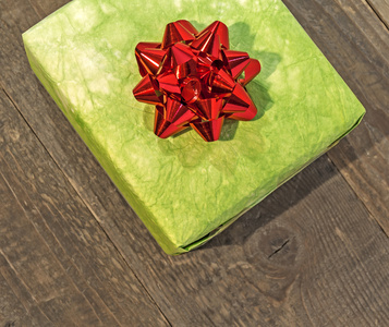 绿色礼品盒木制的桌子上孤立的红色蝴蝶结