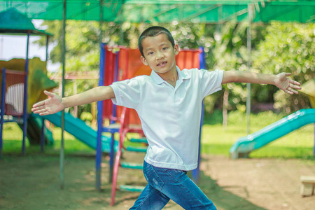 可爱的亚洲孩子在冒险公园玩得开心。英俊的男孩愉快地微笑在孩子操场。亚洲白种混血学步的孩子愉快地玩在室外的操场上夏天的太阳