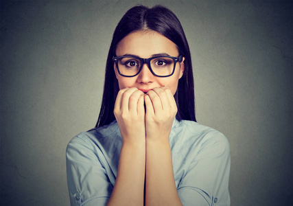 犹豫不决的女人咬手指甲渴望的东西或焦虑照片