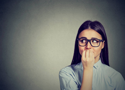 犹豫不决的女人咬手指甲渴望的东西或焦虑照片