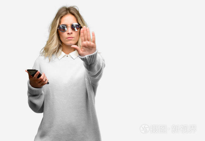年轻漂亮的女人使用智能手机惹恼坏态度做停止手势说不表示安全防御或