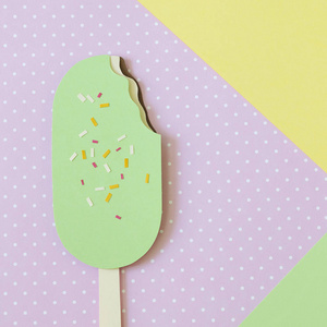 纸冰淇淋在简约的粉彩色彩背景。具有复制空间的夏季概念。剪纸。平躺