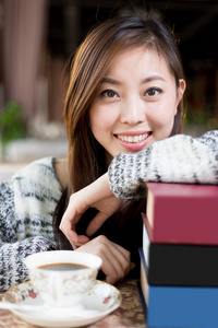 在咖啡馆里的书的年轻中国女子
