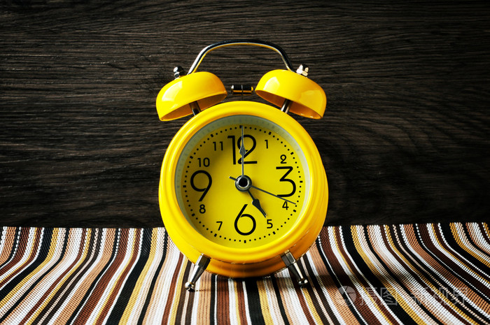 黄色复古闹钟颜色垫上显示 5 点钟水平