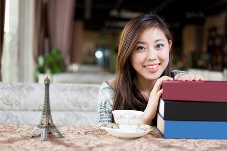 在咖啡馆里的书的年轻中国女子
