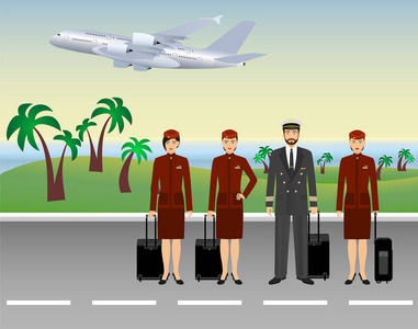 飞行员和空姐的特点, 在飞行飞机的背景上统一站立.航空职员雇员照片