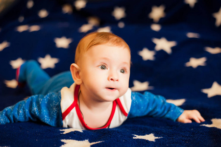 孩子 6 个月旧和微笑在满天星斗的天空蓝色毯子上的家
