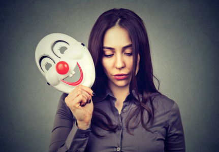 心情不好心理学小丑面具的伤心女人照片